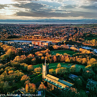 Buy canvas prints of Aerial view of a cityscape at sunset with a prominent cathedral, lush green parks, and a river reflecting the warm sky in Lancaster. by Man And Life