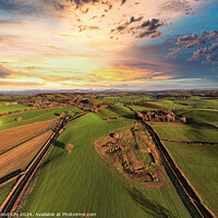 Buy canvas prints of Aerial view of a lush countryside at sunset with vibrant skies and patchwork fields. by Man And Life