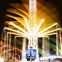 Buy canvas prints of Long exposure of a brightly lit carousel at night, capturing motion blur of spinning lights at a fair. by Man And Life