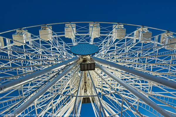 Ferris wheel against a clear blue sky, symmetrical view from below in Lancaster. Picture Board by Man And Life