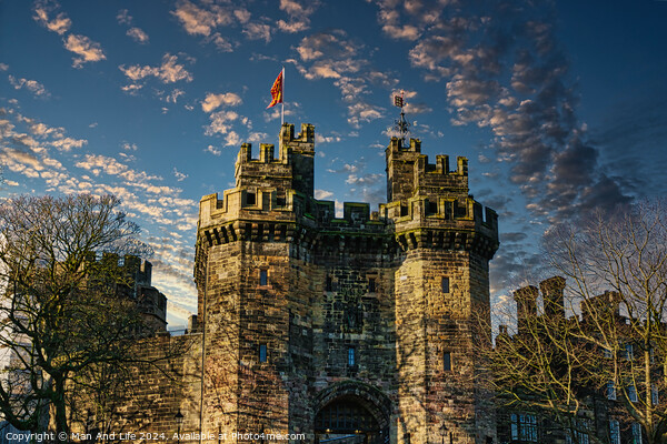 Historic stone castle with towers against a blue sky with scattered clouds at sunset in Lancaster. Picture Board by Man And Life