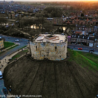 Buy canvas prints of Aerial view of a historic circular stone fortress at dusk, with surrounding urban landscape and sunset sky in York, North Yorkshire by Man And Life