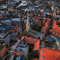 Buy canvas prints of Aerial view of a historic town at dusk with prominent church spire and terracotta rooftops against a moody sky in York, North Yorkshire by Man And Life