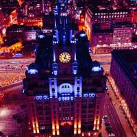 Buy canvas prints of Vertical aerial view of a lit-up cityscape at night with a prominent clock tower and urban streets in Liverpool, UK. by Man And Life