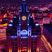 Buy canvas prints of Vertical aerial view of an illuminated historic building at night with city lights in the background in Liverpool, UK. by Man And Life