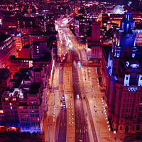 Buy canvas prints of Vertical aerial view of a bustling city street at night with vibrant purple lighting and traffic trails in Liverpool, UK. by Man And Life
