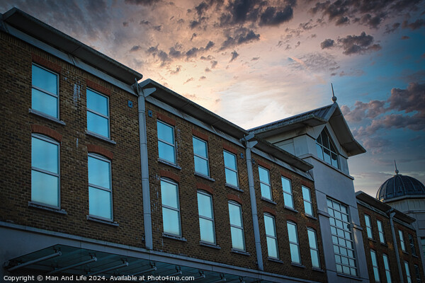 Classic building facade against a dramatic sunset sky with clouds. Picture Board by Man And Life