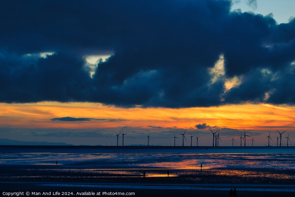 Dramatic sunset over a beach with silhouetted wind turbines on the horizon and reflective wet sand in Crosby, England. Picture Board by Man And Life