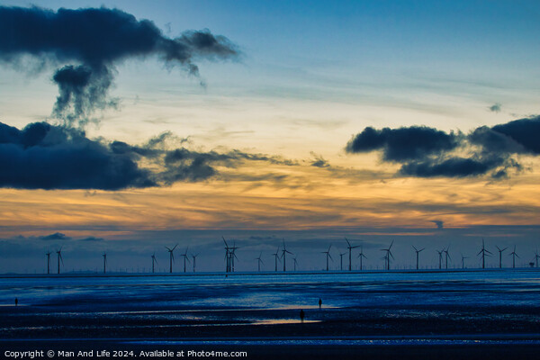 Serene sunset over a wind farm with silhouettes of turbines and dramatic clouds, reflecting on water in Crosby, England. Picture Board by Man And Life