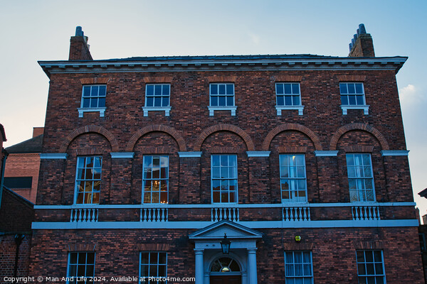 Traditional brick building facade under blue sky at dusk in York, UK. Picture Board by Man And Life