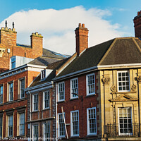 Buy canvas prints of Historic brick buildings with classic British architecture under a clear blue sky in York, UK. by Man And Life