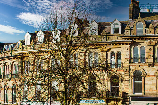 Vintage building corner against a dramatic cloudy sky in Harrogate, England. Picture Board by Man And Life