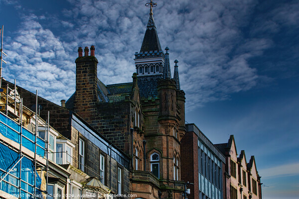 Historic architecture with a spire against a dramatic sky, flanked by modern buildings and scaffolding in Harrogate, England. Picture Board by Man And Life