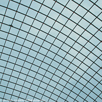 Buy canvas prints of Abstract geometric pattern of a glass ceiling against a clear blue sky. by Man And Life