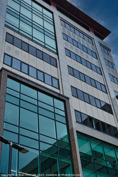 Modern office building facade with reflective glass windows against a blue sky in Leeds, UK. Picture Board by Man And Life