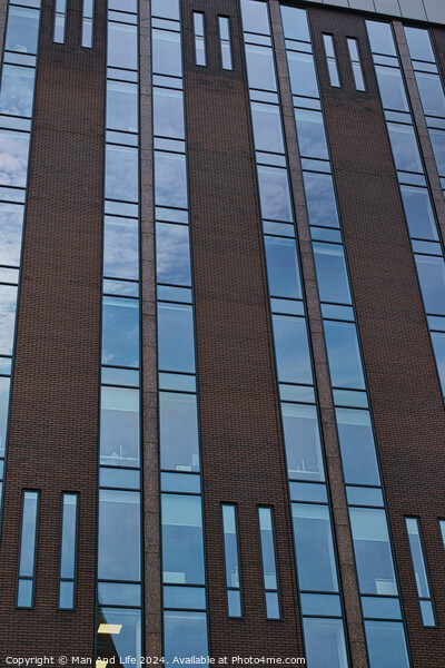 Modern building facade with a pattern of windows and brickwork against a blue sky in Leeds, UK. Picture Board by Man And Life