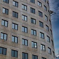 Buy canvas prints of Modern curved office building facade against a clear blue sky in Leeds, UK. by Man And Life
