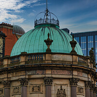 Buy canvas prints of Vintage green dome of a classical building against a blue sky with modern skyscrapers in the background in Leeds, UK. by Man And Life