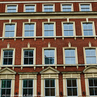 Buy canvas prints of Facade of a classic red brick building with symmetrical windows against a clear sky in Leeds, UK. by Man And Life