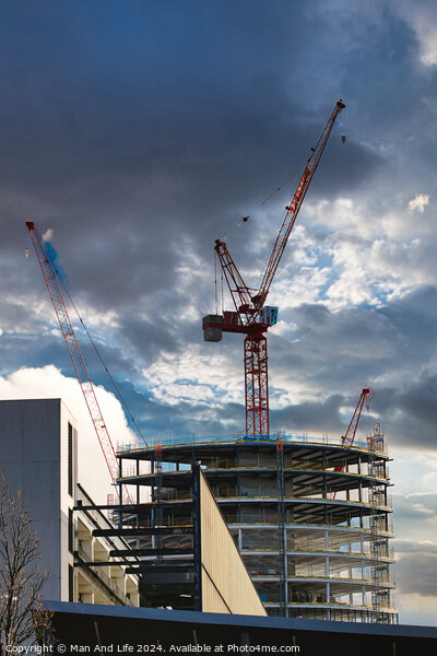 Construction site with cranes against a dramatic cloudy sky, symbolizing development and architecture in Liverpool, UK. Picture Board by Man And Life