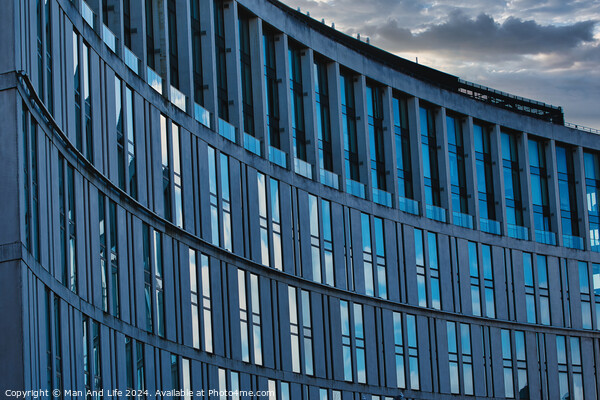 Modern office building facade with reflective glass windows against a cloudy sky at dusk in Liverpool, UK. Picture Board by Man And Life