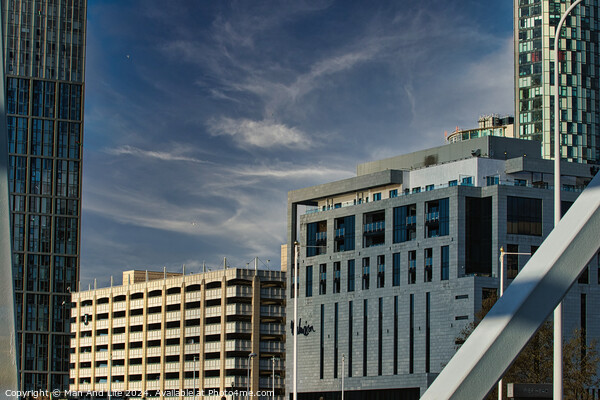 Modern cityscape with skyscrapers and a construction site against a blue sky with clouds in Liverpool, UK. Picture Board by Man And Life