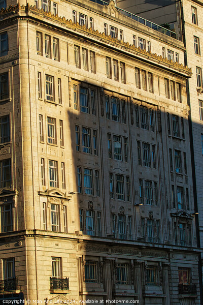 Sunlight casting shadows on a classic urban building facade during golden hour, highlighting architectural details in Liverpool, UK. Picture Board by Man And Life