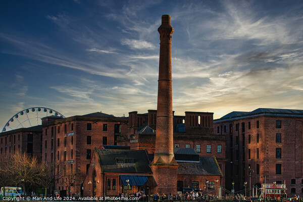 Historic red brick buildings with tall chimney against a dramatic sunset sky, with a Ferris wheel in the background in Liverpool, UK. Picture Board by Man And Life