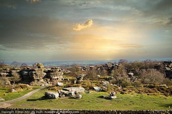Picturesque rural landscape at sunset with rocky formations and green fields under a cloudy sky at Brimham Rocks, in North Yorkshire Picture Board by Man And Life