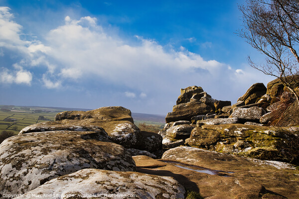 Scenic view of rugged rocks against a blue sky with fluffy clouds, highlighting the natural beauty of a mountainous landscape at Brimham Rocks, in North Yorkshire Picture Board by Man And Life