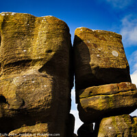 Buy canvas prints of Majestic rock formations against a blue sky with clouds, showcasing natural erosion and geological textures at Brimham Rocks, in North Yorkshire by Man And Life
