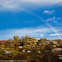 Buy canvas prints of Vibrant rainbow over a rocky landscape with scattered boulders and lush greenery under a blue sky with clouds at Brimham Rocks, in North Yorkshire by Man And Life