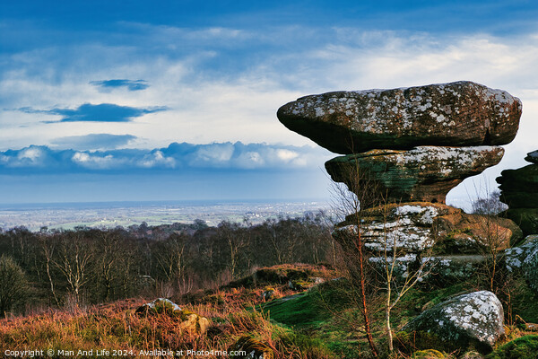 Scenic view of a unique rock formation in a lush landscape with dramatic clouds in the sky at Brimham Rocks, in North Yorkshire Picture Board by Man And Life