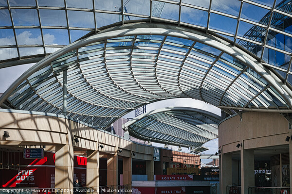 Modern glass ceiling architecture at a shopping mall with blue sky and clouds visible through the transparent structure in Leeds, UK. Picture Board by Man And Life