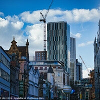 Buy canvas prints of Urban cityscape with historic buildings and modern skyscraper under construction against a blue sky with clouds in Leeds, UK. by Man And Life
