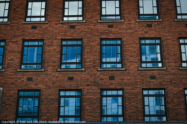 Symmetrical brick building facade with rows of blue windows, urban architecture background in Leeds, UK. Picture Board by Man And Life