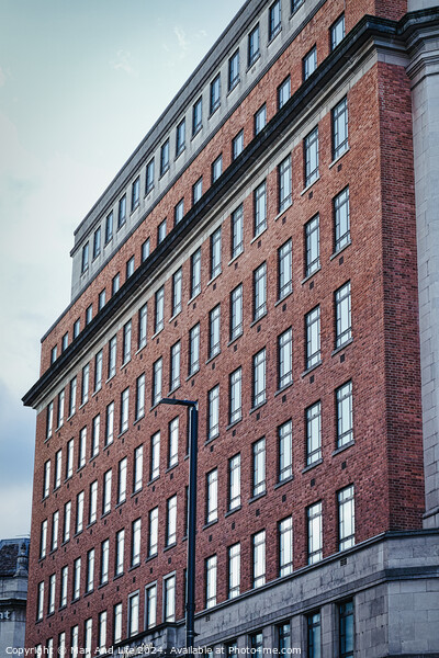 Facade of a red brick office building with multiple windows under a cloudy sky, showcasing urban architecture in Leeds, UK. Picture Board by Man And Life