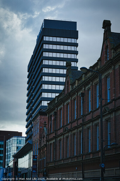 Contrast of old and new architecture with a modern skyscraper towering behind a classic brick building under a cloudy sky in Leeds, UK. Picture Board by Man And Life