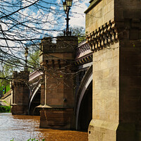 Buy canvas prints of Scenic view of an old stone bridge with arches over a river, framed by blue skies and greenery, with a vintage street lamp adding to the historic charm in York, North Yorkshire, England. by Man And Life