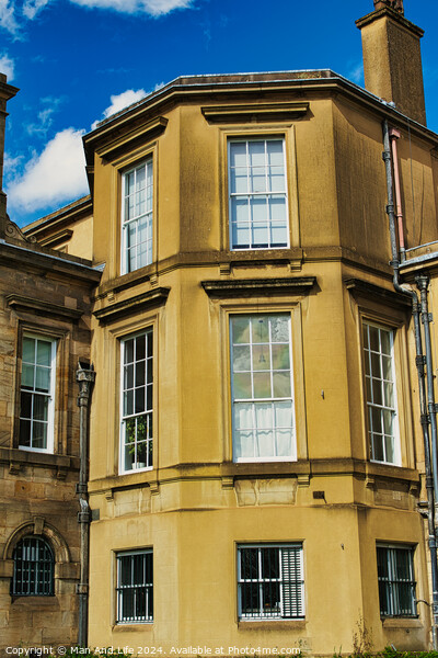 Classic European architecture with a clear blue sky. The building features a warm beige facade, large windows, and traditional stonework details in York, North Yorkshire, England. Picture Board by Man And Life