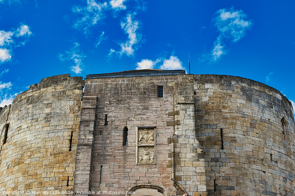 Medieval stone fortress against a vibrant blue sky with fluffy clouds, showcasing ancient architecture and historical military construction in York, North Yorkshire, England. Picture Board by Man And Life