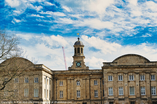 Historic stone building with a central clock tower under a blue sky with fluffy clouds, featuring classic architecture and a construction crane in the background in York, North Yorkshire, England. Picture Board by Man And Life