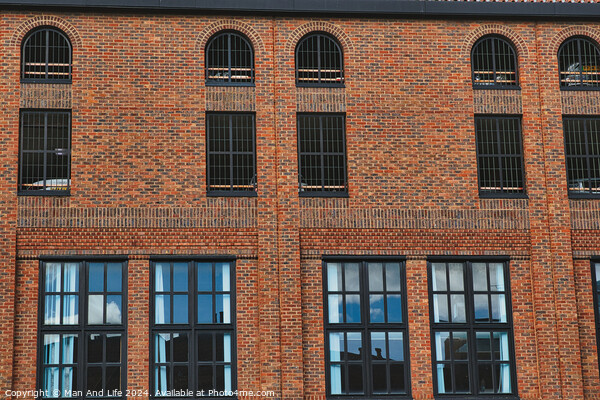 Facade of a vintage brick building with rows of windows reflecting the sky, showcasing industrial architecture in York, North Yorkshire, England. Picture Board by Man And Life