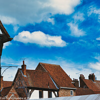 Buy canvas prints of Quaint European village with traditional half-timbered houses and terracotta rooftops under a vibrant blue sky with fluffy clouds in York, North Yorkshire, England. by Man And Life