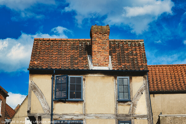 Old European house with half-timbered walls and a red tiled roof against a blue sky with clouds. Vintage architecture with visible wear and character in York, North Yorkshire, England. Picture Board by Man And Life