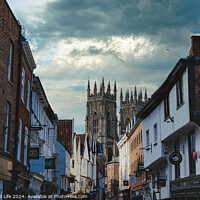 Buy canvas prints of Quaint European street leading to a majestic Gothic cathedral under a dramatic sky at dusk, showcasing historical architecture and urban charm in York, North Yorkshire, England. by Man And Life