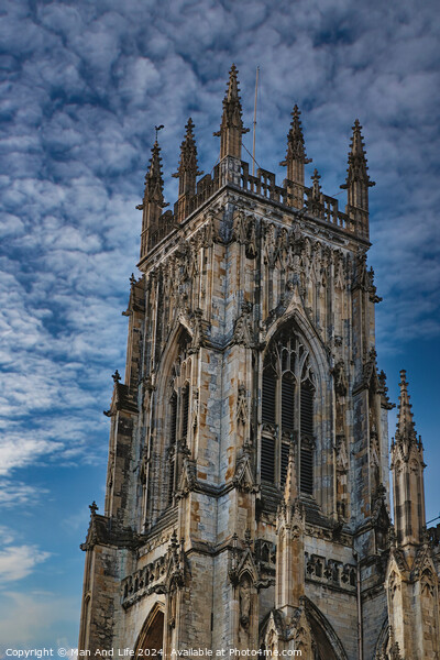 Gothic cathedral tower against a dramatic cloudy sky, showcasing intricate architectural details and spires, ideal for historical or religious themes in York, North Yorkshire, England. Picture Board by Man And Life