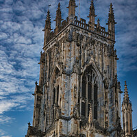 Buy canvas prints of Gothic cathedral tower against a dramatic cloudy sky, showcasing intricate architectural details and spires, ideal for historical or religious themes in York, North Yorkshire, England. by Man And Life