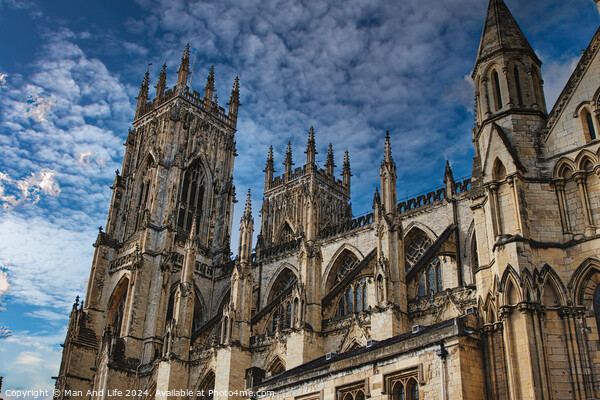 Gothic cathedral tower against a dramatic cloudy sky, showcasing intricate architectural details and spires, ideal for historical or religious themes in York, North Yorkshire, England. Picture Board by Man And Life