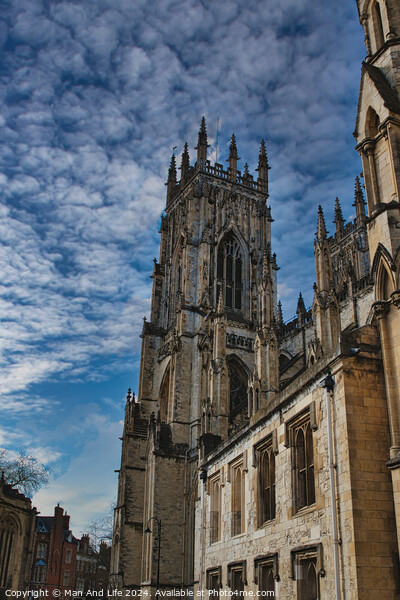 Gothic cathedral against a dramatic sky with fluffy clouds, showcasing intricate architecture and historical grandeur, ideal for travel and cultural themes in York, North Yorkshire, England. Picture Board by Man And Life